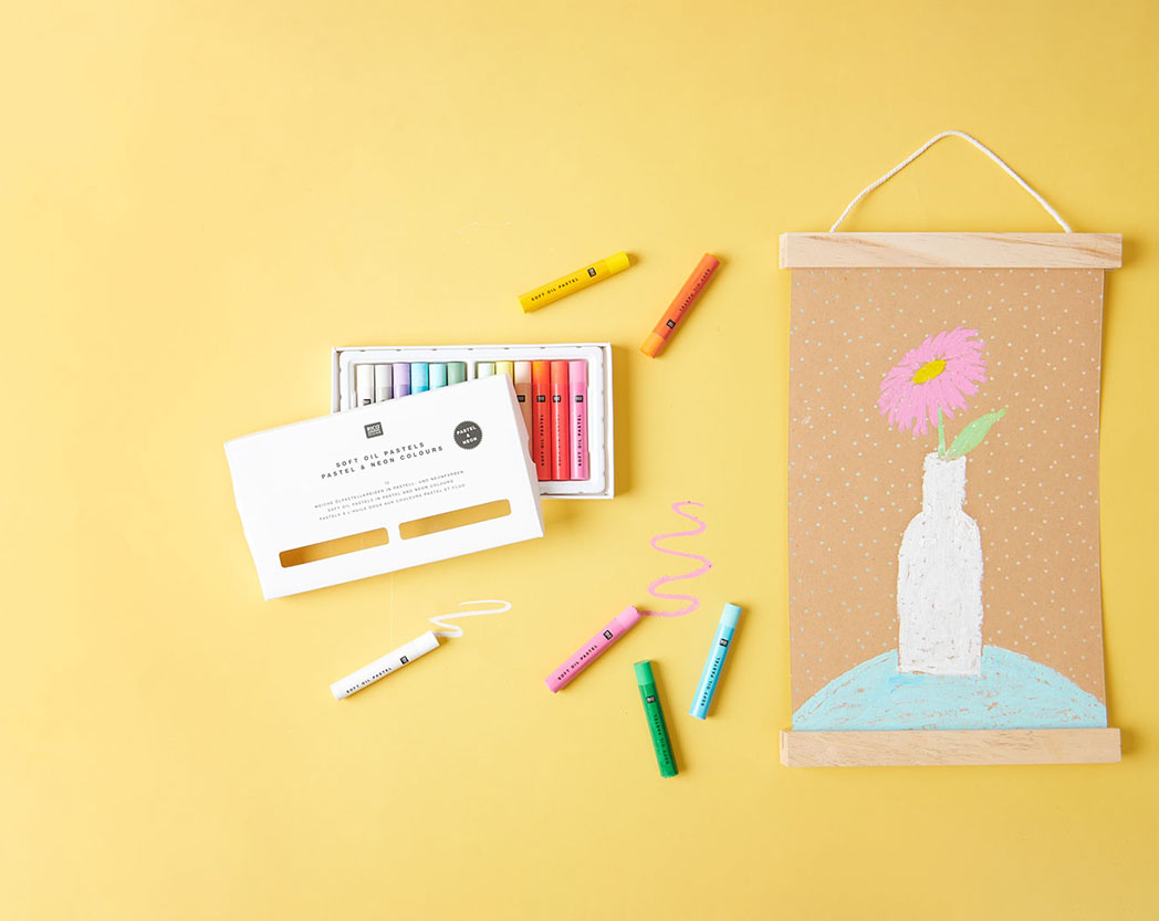 Eine gemalte Vase mit Blume und daneben eine Schachtel mit Kreide. Flatlay von produkten.