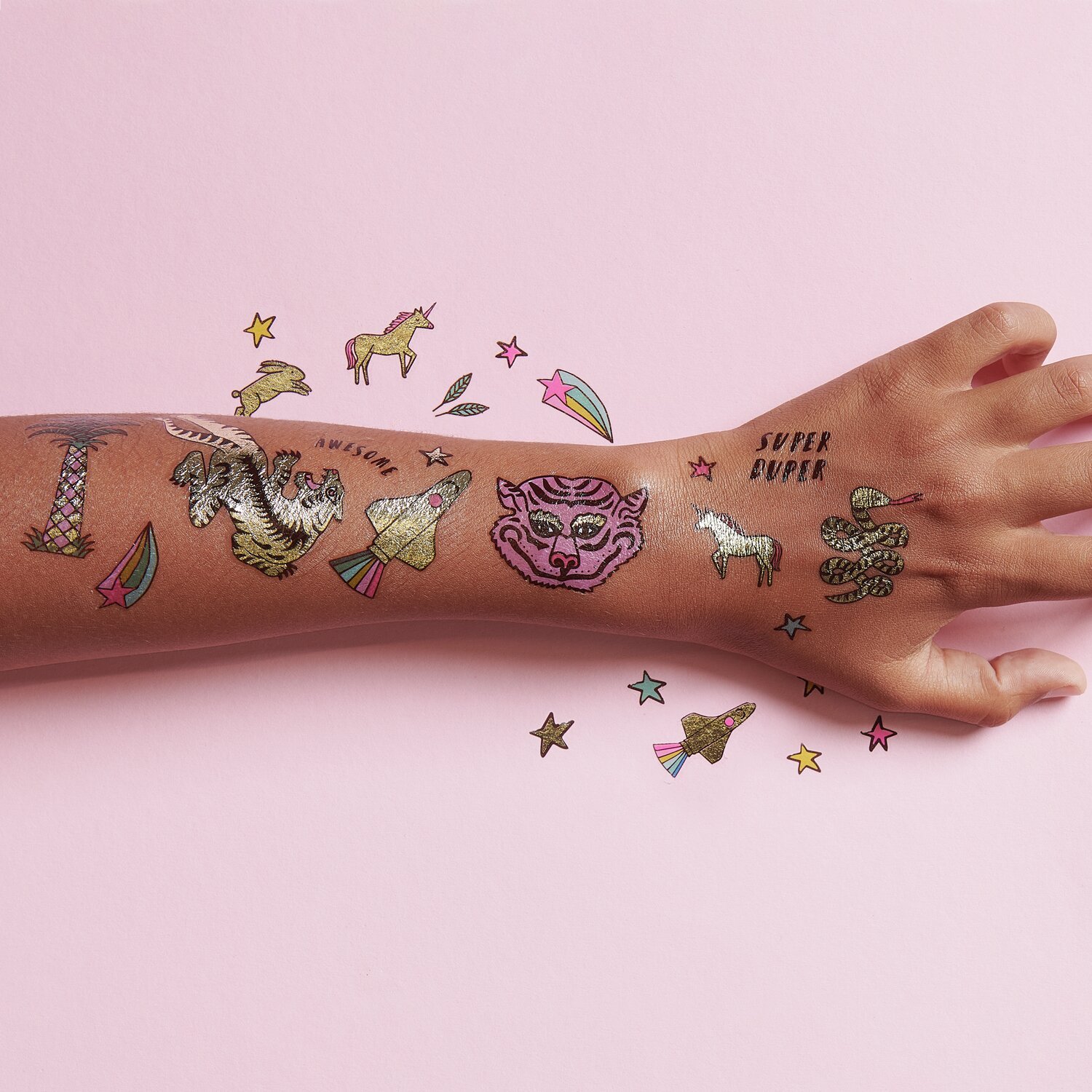 Tattoos Wonderland: Temporäre Tattoos auf einem Arm, bunte Designs mit Einhörnern und Sternen.