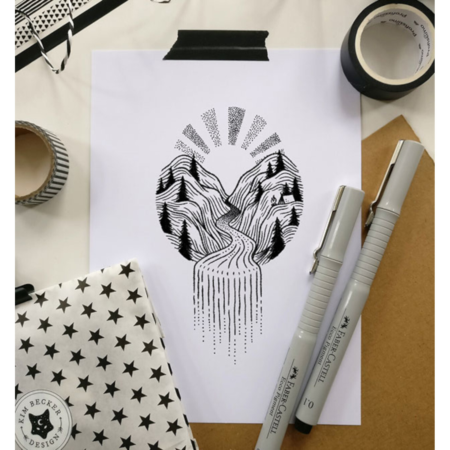 Fine Line: Schwarz-weiße Landschaftszeichnung mit Bergen und Fluss, umgeben von Stiften und Notizbuch.