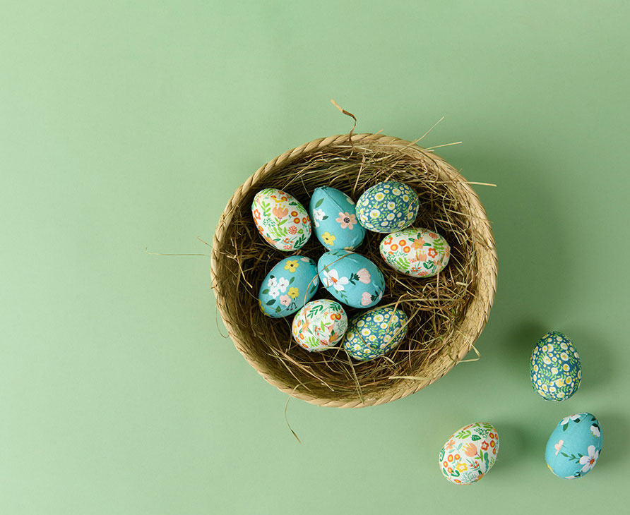 Bunte Ostereier liegen in Körbchen mit Ostergras