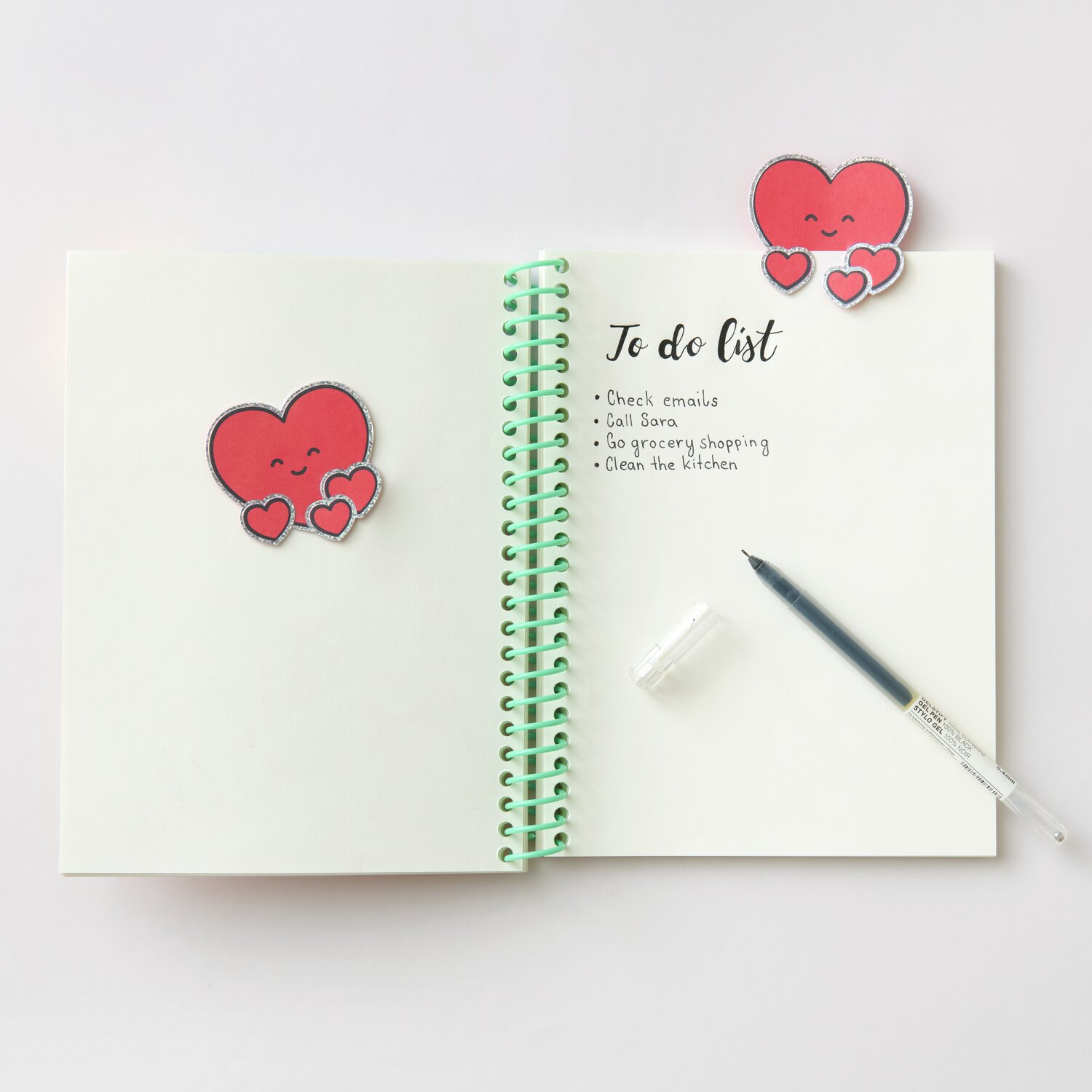 Paper Poetry Clip-Ons Chingu Herzen Rot, 8-teilig. Zwei rote Herz-Clips auf einem Notizbuch.