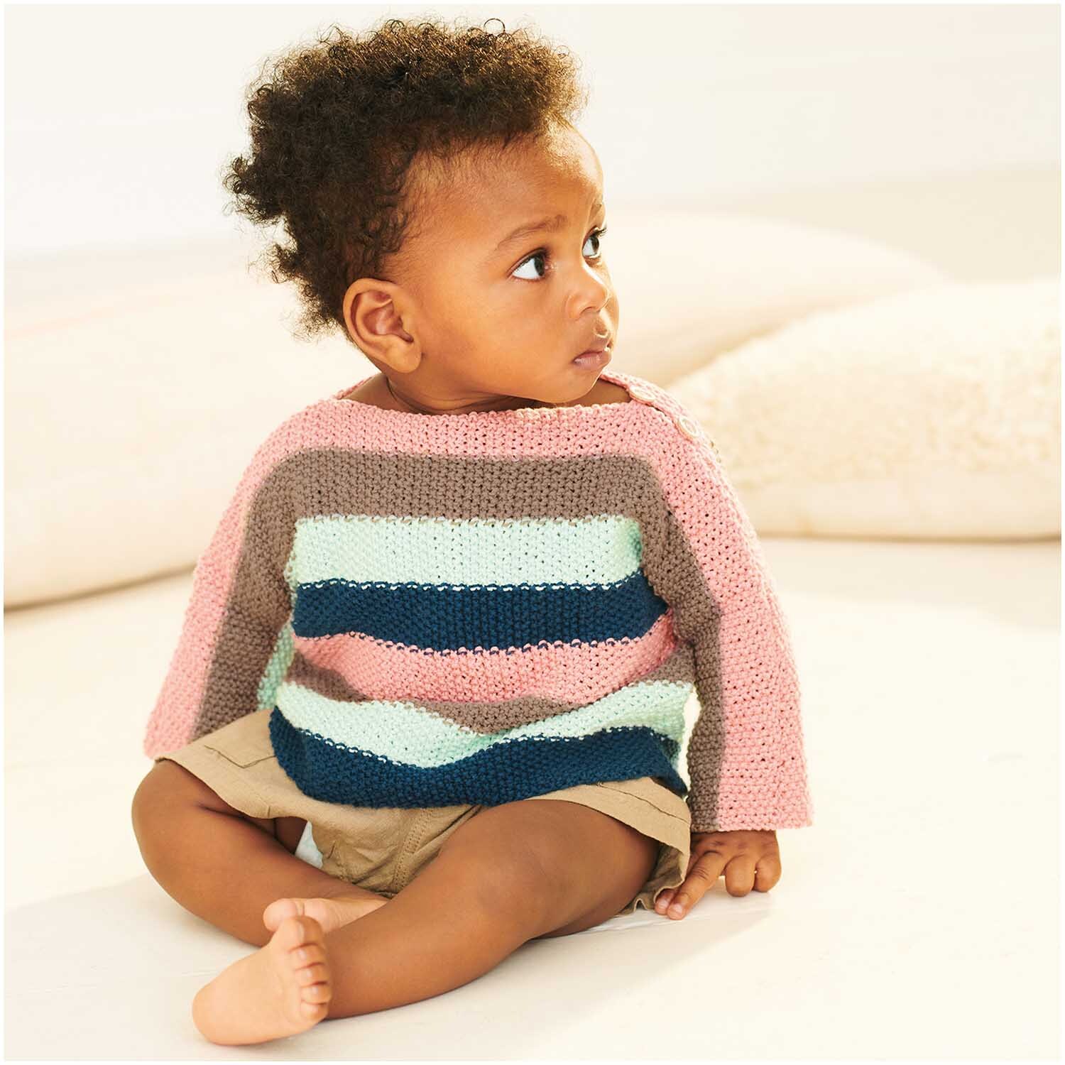 Baby Organic Cotton 50g 150m Farbe Marine von Rico Design Baby Organic Cotton: Ein Kleinkind trägt einen gestreiften Pullover aus Bio-Baumwolle von Rico Design.