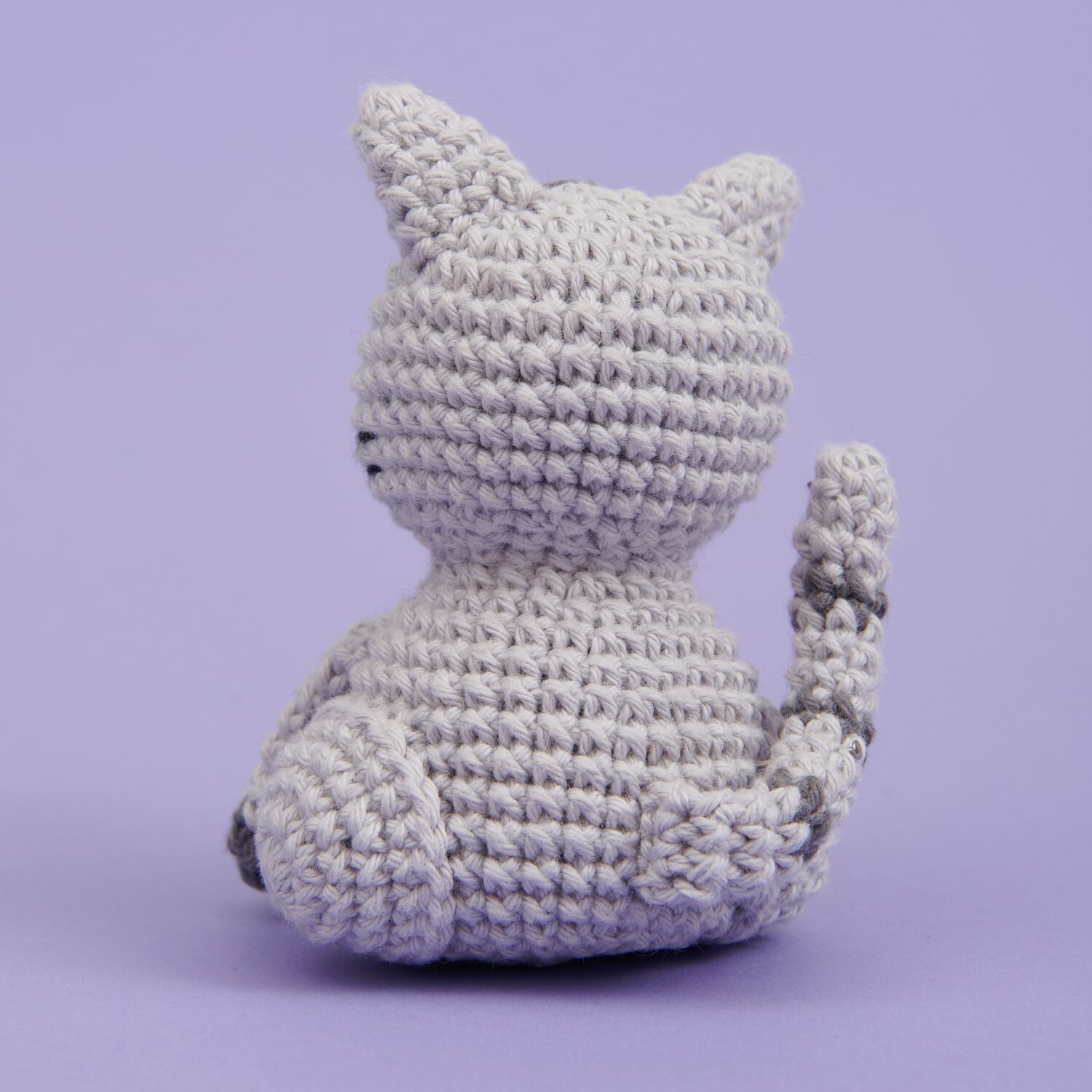 Ricorumi Mini Easy Häkelset - Katze: Graue, gehäkelte Katze von hinten auf lila Hintergrund. Ideal für Anfänger.