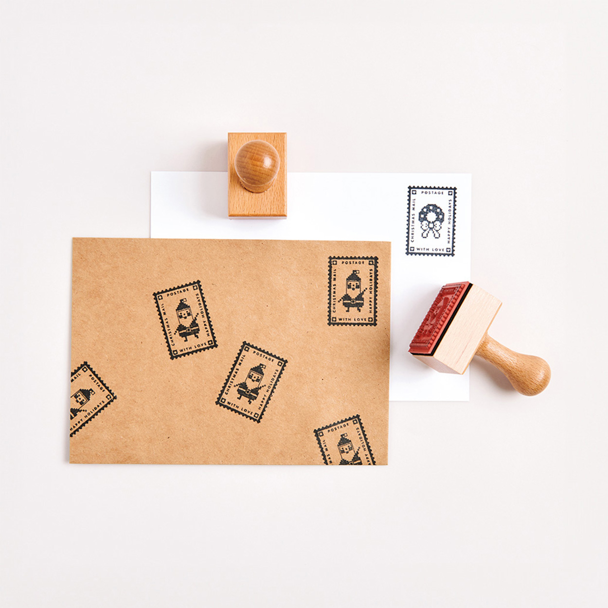 Weißer und brauner Umschlag übereinandergelegt und mit Stempel verziert. Flatlay von Produkten.