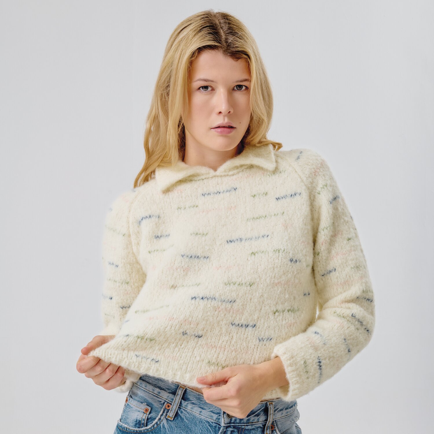 Strickset Pullover Modell 13b aus Made by Me No. 21 von Rico Design Strickset Pullover Modell 13b aus Made by Me No. 21, cremefarbener Pullover mit dezentem Muster, getragen von einer Frau in Jeans.