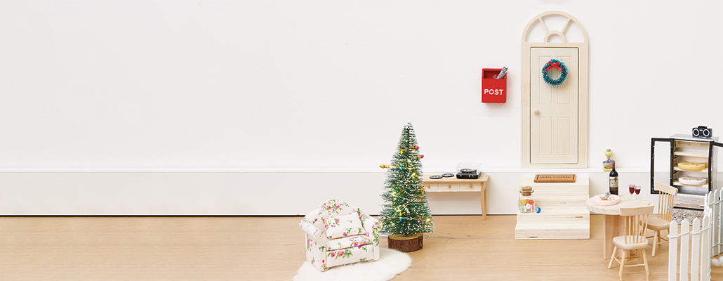 Eine Wichtelwelt bestehend aus einer Tür, Treppe, Weihnachtsbaum, Tisch und Sessel. Fotosetting Fußleiste.