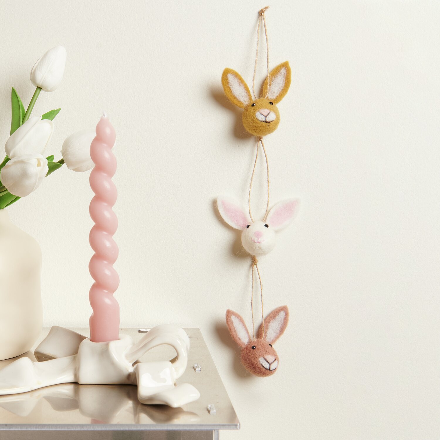 Aufhänger Filz-Hasenkopf 3 Stück: Drei bunte Hasenköpfe aus Filz an einer Wand, dekorativ aufgehängt.