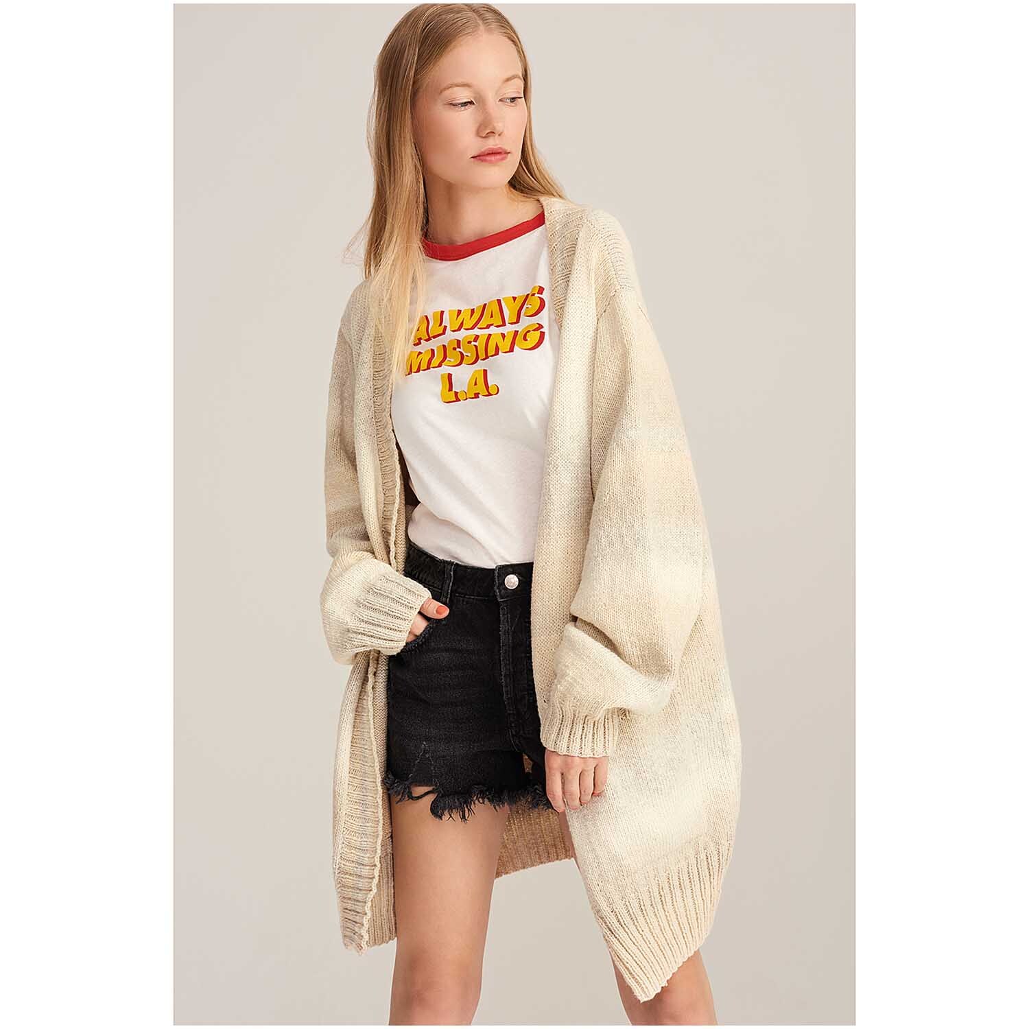 Fashion Cotton Light & Long dk 50g 185m Farbe Natur von Rico Design Fashion Cotton Light & Long dk: Frau trägt langen, beigen Cardigan von Rico Design über T-Shirt und Shorts.