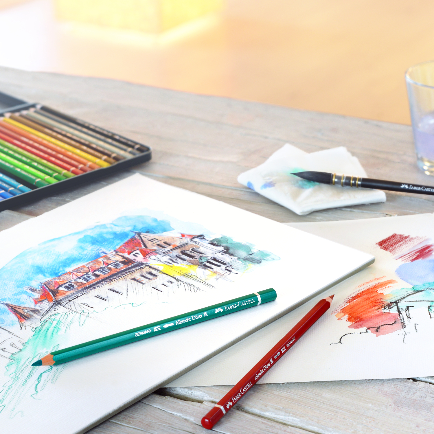 Albrecht Dürer Aquarellstift Farbe Alizarin-karmesin von Faber-Castell Albrecht Dürer Aquarellstift von Faber Castell auf einem Tisch mit Skizzen und Malutensilien.