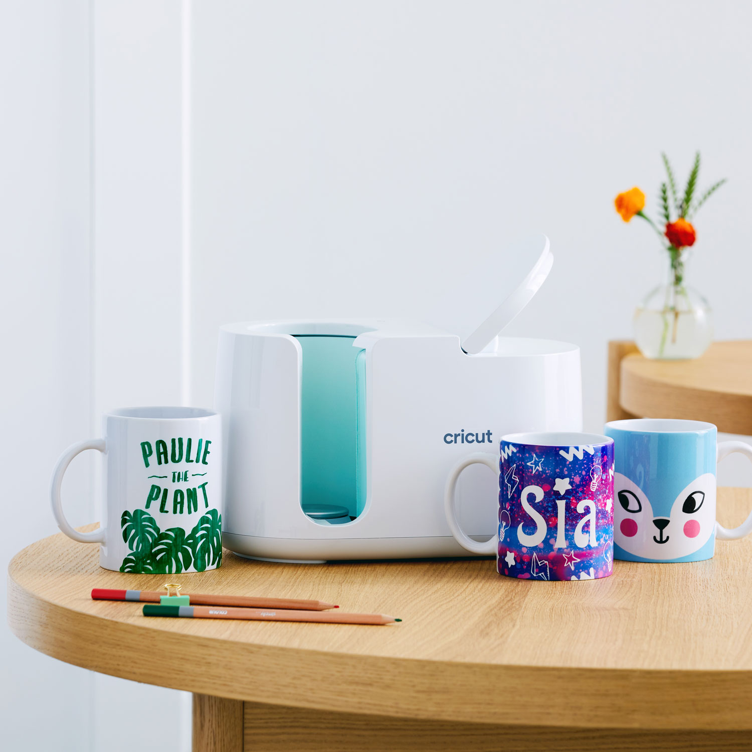 Mug Press mit drei fertig gepressten Tassen in unterschiedlichen Designs.