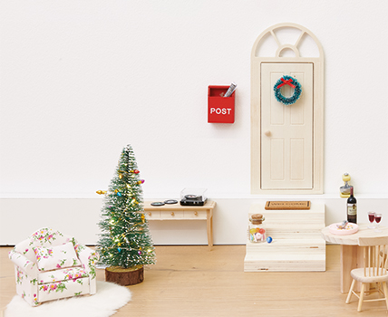 Eine Wichtelwelt bestehend aus einer Tür, Treppe, Weihnachtsbaum, Tisch und Sessel. Fotosetting Fußleiste.