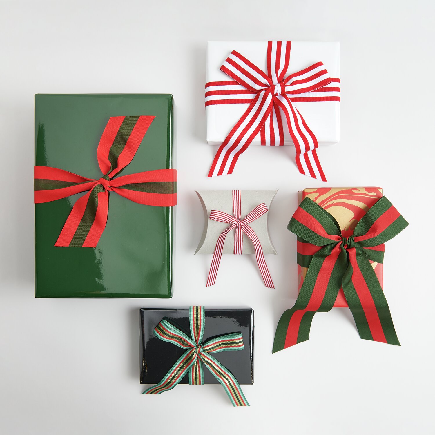 Geschenkpapier Lack 200x70cm: Fünf Geschenke mit farbigen Bändern, darunter Rot/Grün und Rot/Weiß.