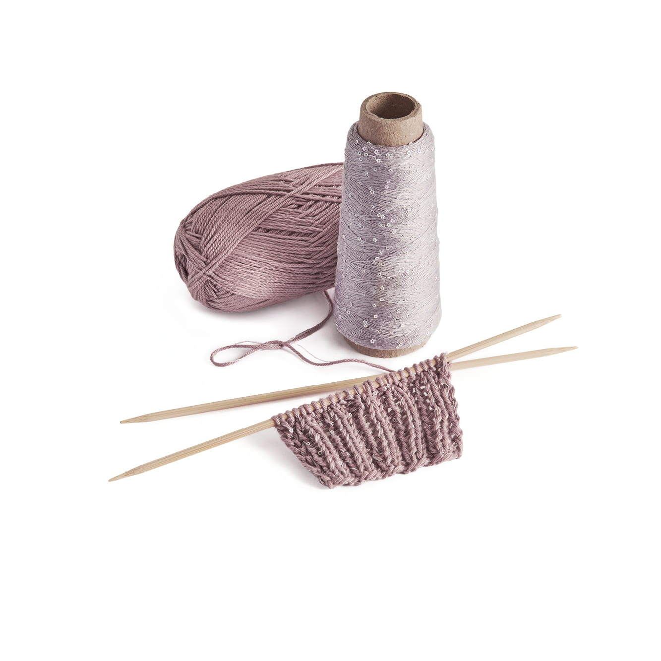 Ein Wollknäuel und ein Beilaufgarn liegen neben einem Strickstück auf Stricknadeln