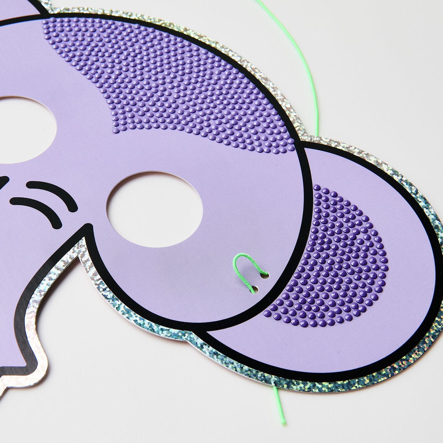 Diamond Painting Masken Tiere, lila Elefantenmaske mit glitzernden Details und grünem Band.