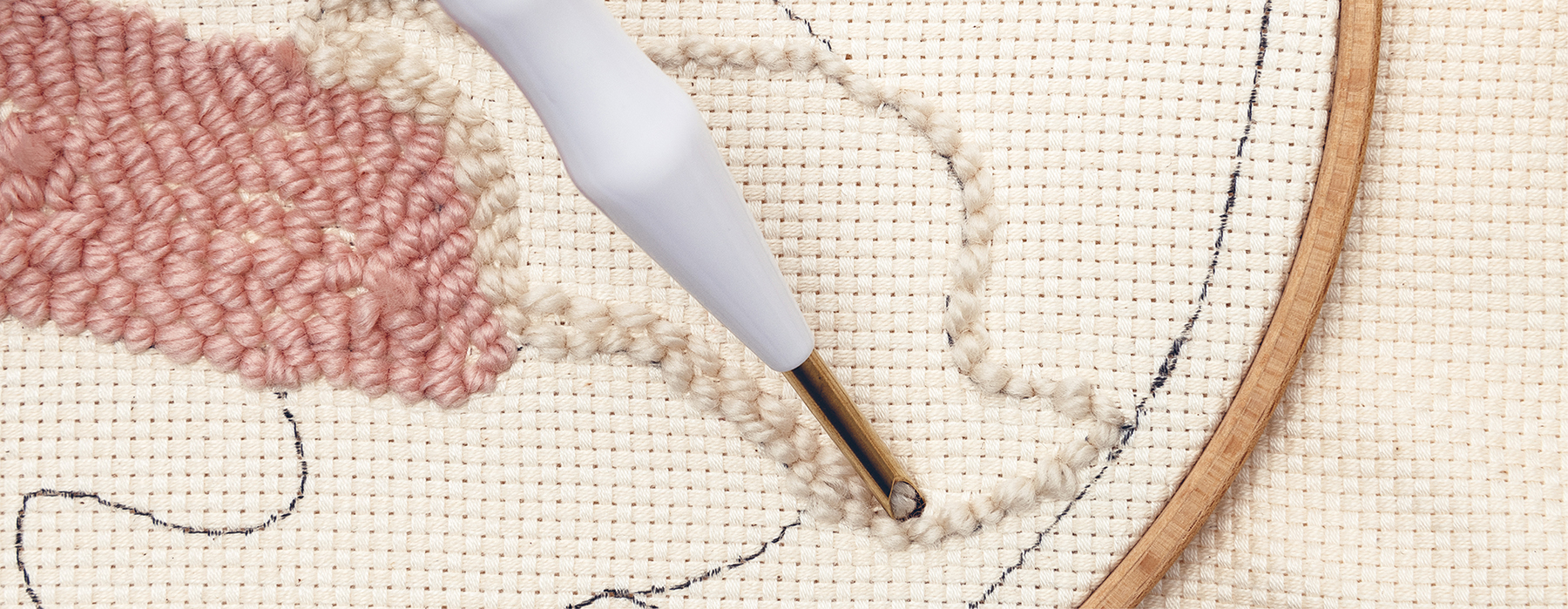 Punch Needle stickt Wolle in einen Stoff