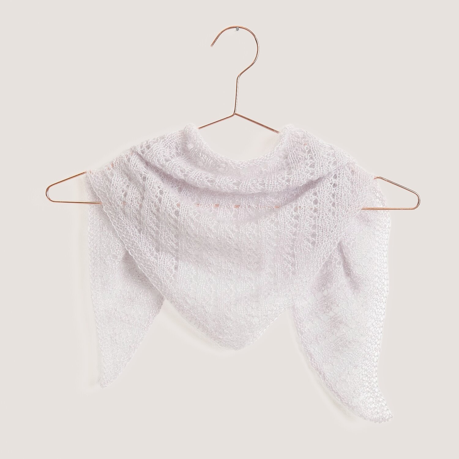 Strickset Dreieckstuch Modell 08 aus fliederfarbenem Mohair-Seide-Garn, elegant drapiert auf einem Kleiderbügel.