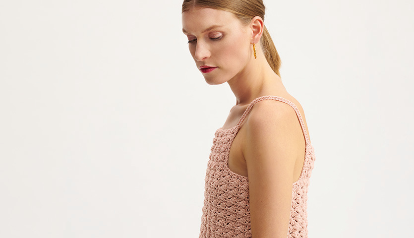 Häkelanleitung Top aus Essentials Organic Cotton aran: Frau trägt rosa gehäkeltes Top.