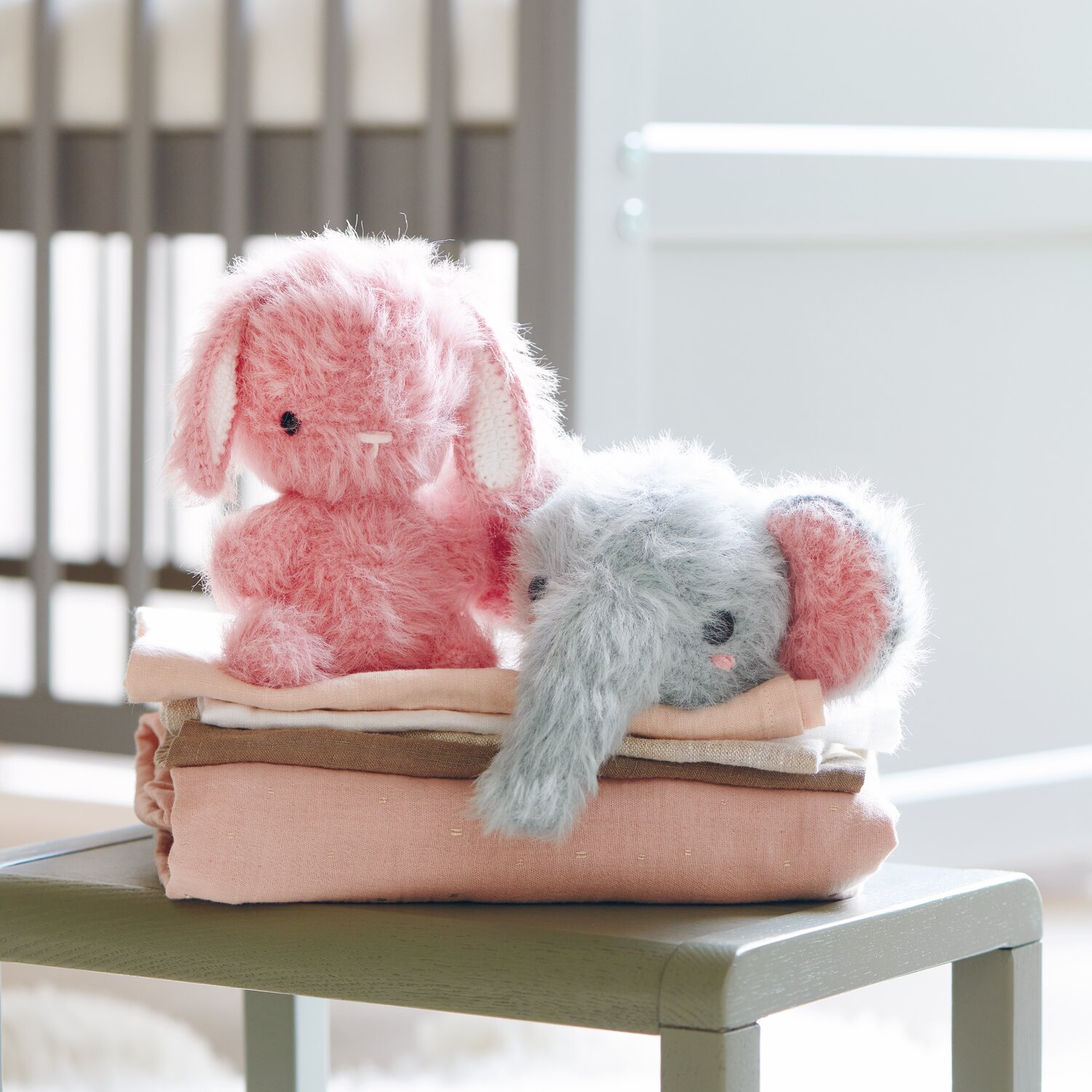 Ricorumi Furry Animals: Zwei flauschige Stofftiere, Hase in Pink und Elefant in Patina, auf gefalteten Decken.