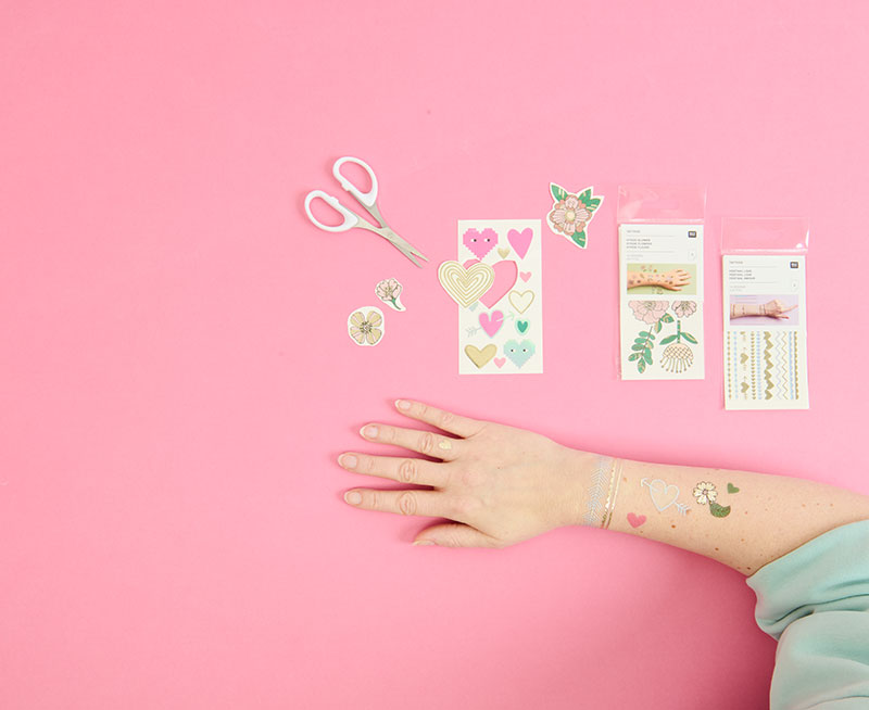 Temporäre Tattoos werden auf Arm befestigt