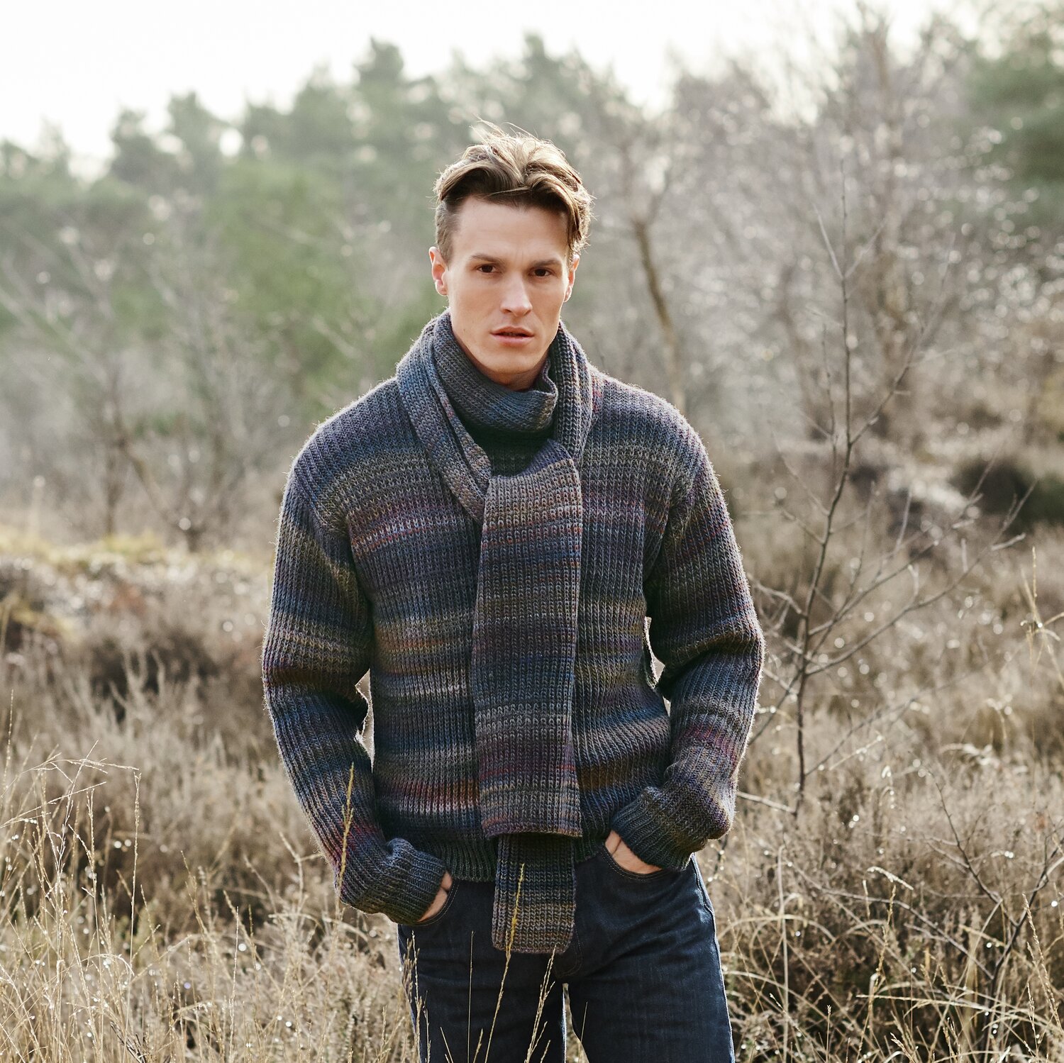 Strickset Pullover Modell 24 aus Lovewool No. 21 von Rico Design Strickset Schal Modell 25 aus Lovewool No. 21: Mann trägt gestrickten Schal und Pullover in Naturkulisse.