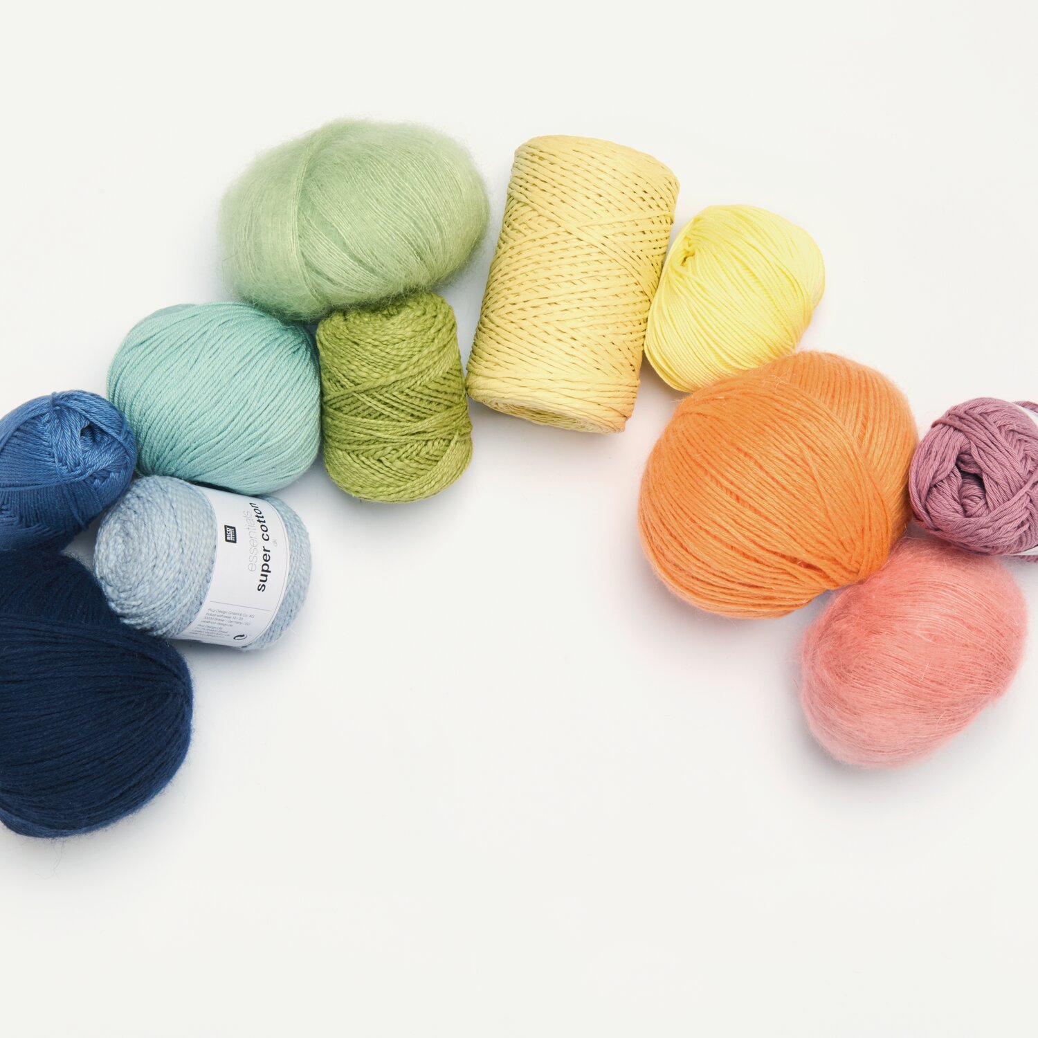 Creative Cotton Fleece dk: Bunte Wollknäuel in Blau, Grün, Gelb und Orange von Rico Design auf weißem Hintergrund.