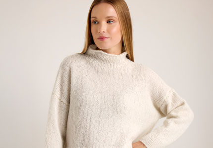 Frau trägt einen weißen Strickpuli