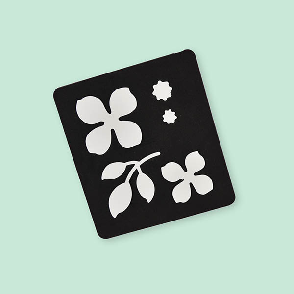 Schablone mit schwarzem Hintergrund und weißen Blumen. Flatlay von Produkt.