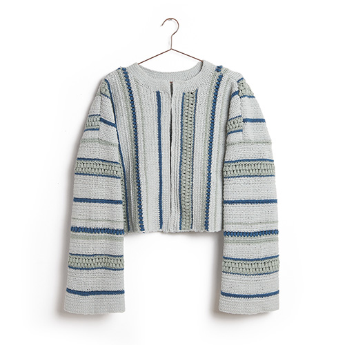 Eine gestrickte Jacke mit Streifenmuster hängt an einem Kleiderbügel.