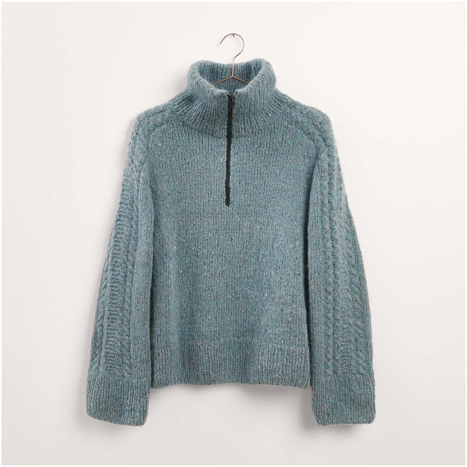 Pullover in Blau mit hohem Kragen und Reißverschluss, aus der Kollektion "Made by Me Nr. 17". Strickset Modell 22, präsentiert als Legeware. Ideal für kühle Tage.