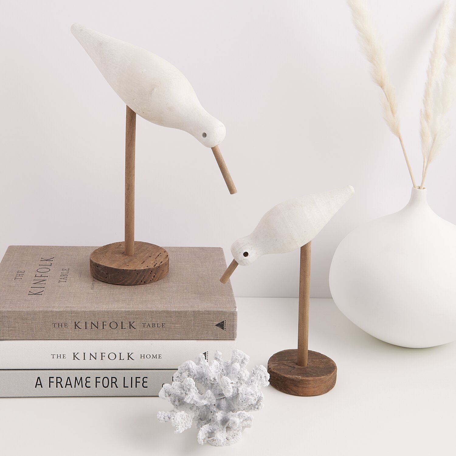 Koralle aus Polyresin weiß 14x11x9cm vor Büchern und Deko-Vögeln auf Holzbasis, minimalistisch arrangiert.