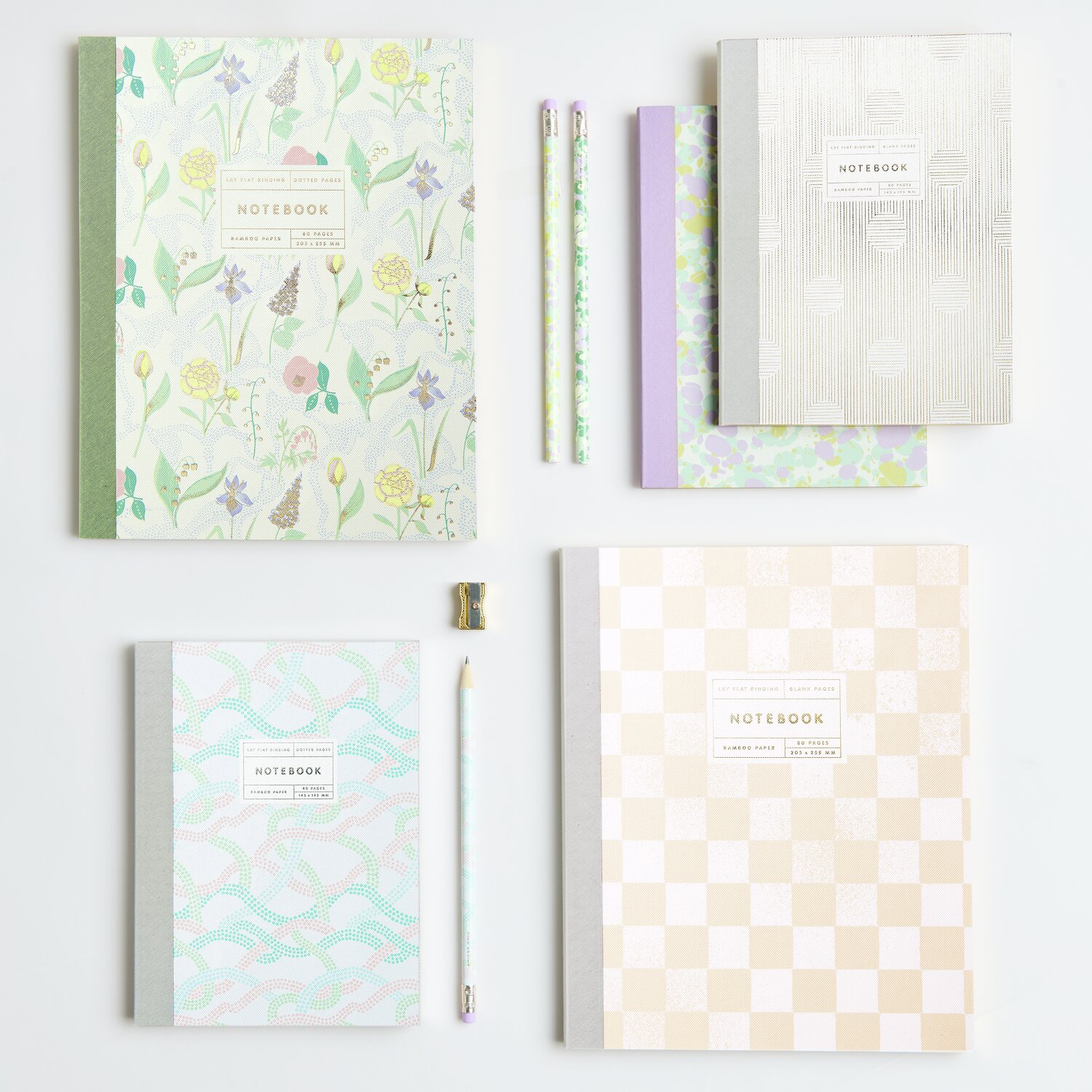 Paper Poetry Notizbuch Sky L Blumen mit floralem Muster, begleitet von Bleistiften und weiteren Notizbüchern in Pastelltönen.