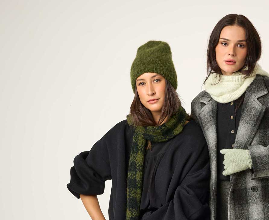 Zwei Frauen tragen Strickmütze, Strickschal und Loop und Handschuhe