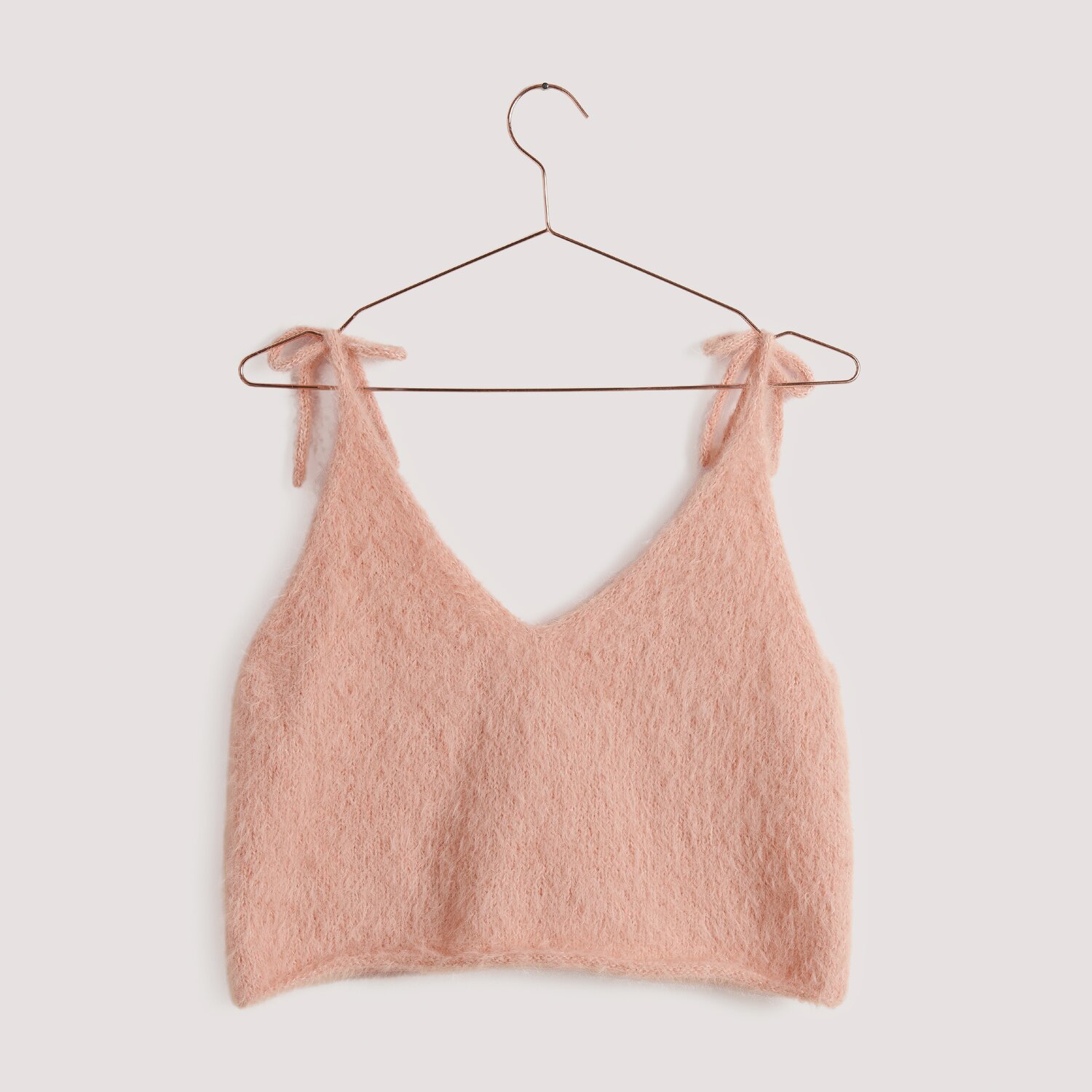 Essentials Super Kid Mohair Loves Silk Top in Apricot auf einem Kleiderbügel, ideal für Frühling und Sommer.