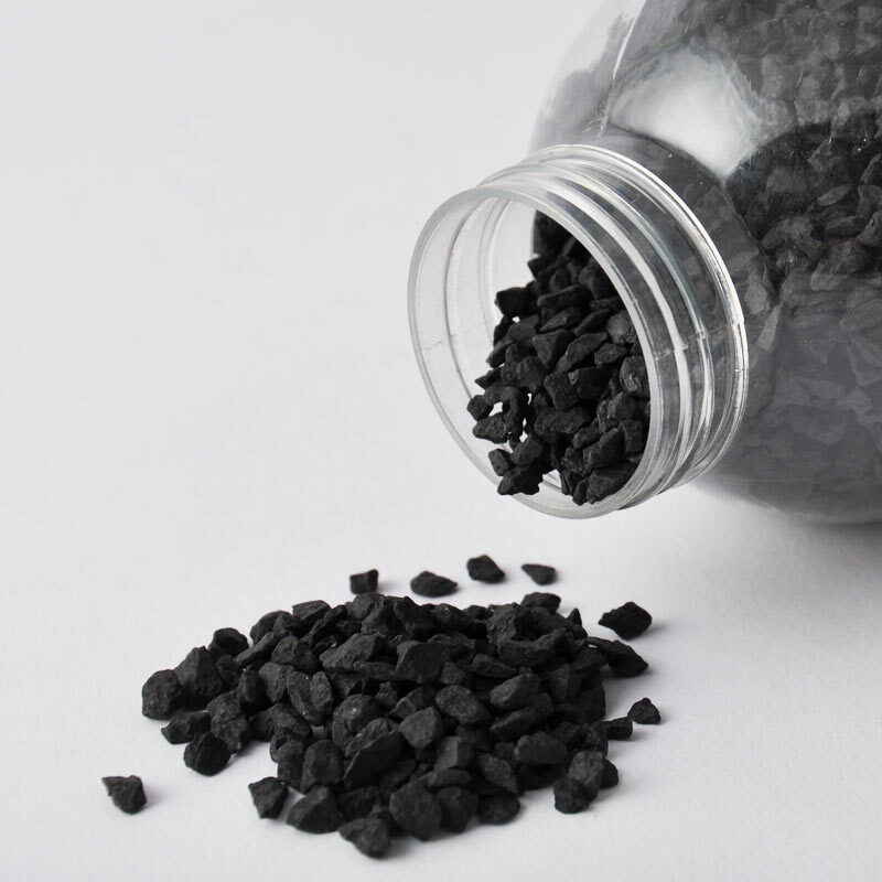 Dekosteine 810g: Schwarze Steine aus einem transparenten Behälter, ideal für kreative Projekte.