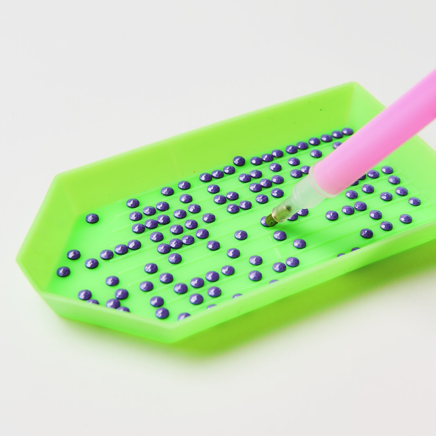 Diamond Painting DIY-Set Schimmernde Blumen 19-teilig: Grünes Tablett mit lila Steinen und pinkem Stift. Ideal für kreative Bastelprojekte.