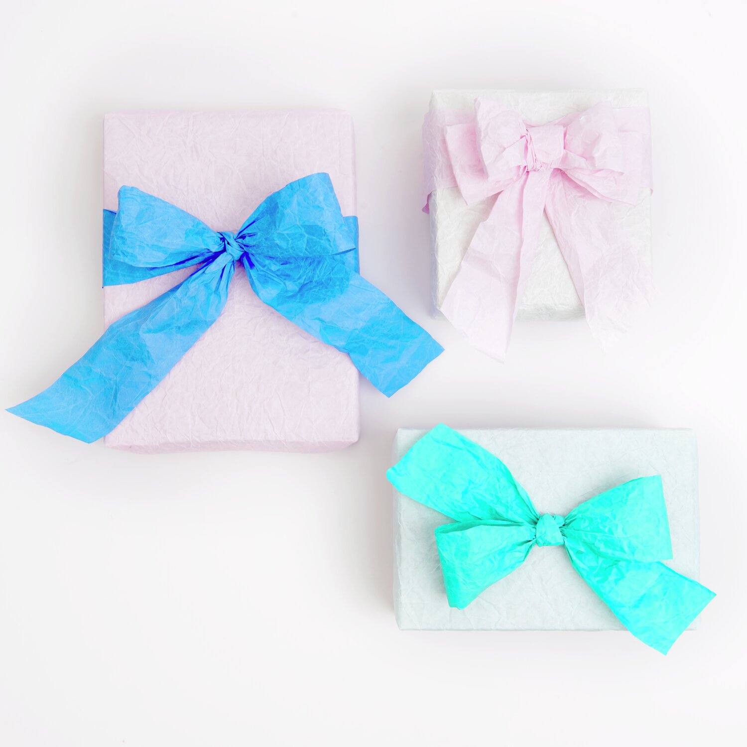 Knitter Geschenkpapier Mix mit farbigen Papierbändern in Blau und Rosa, dekorativ verpackt.