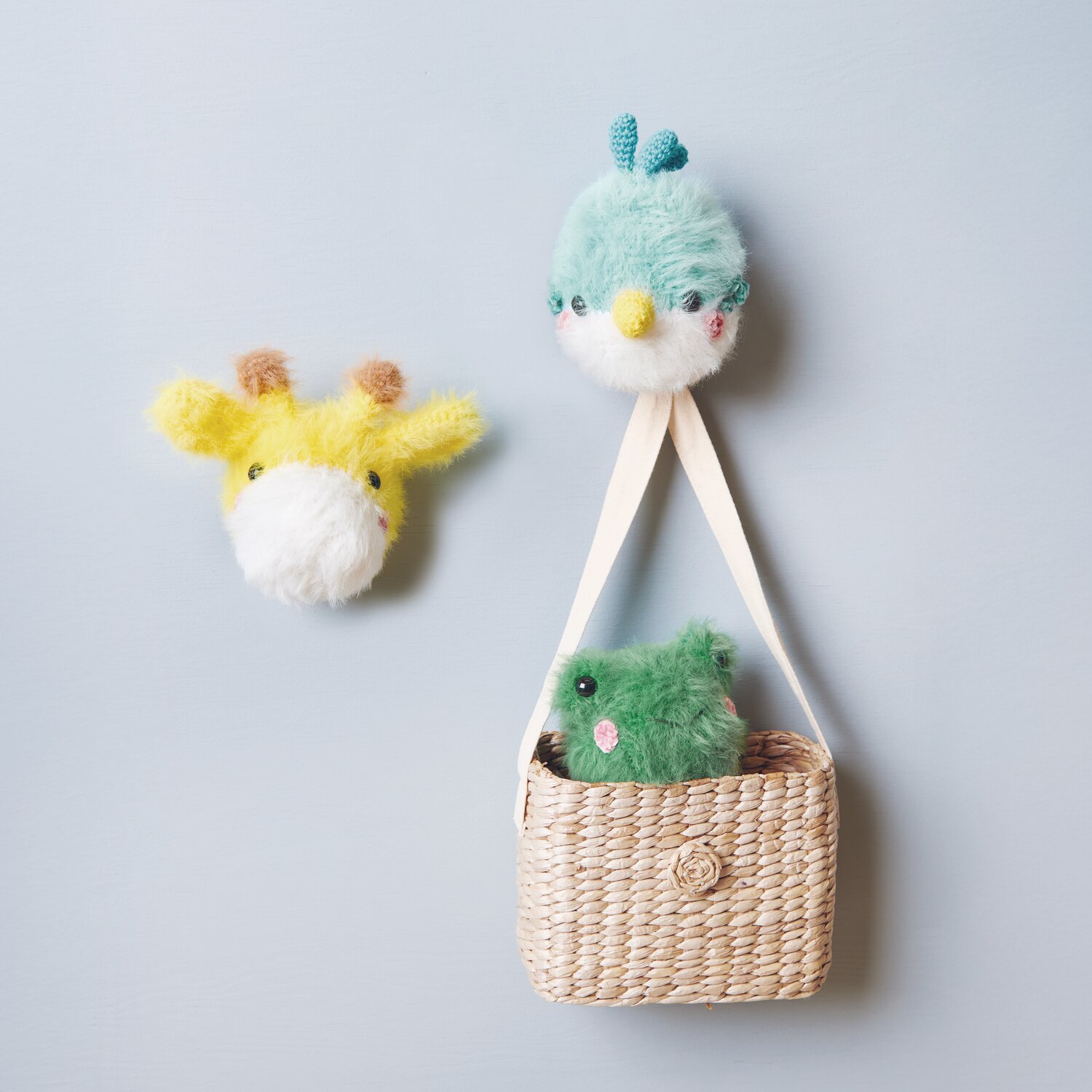 Creative Ricorumi dk 25g Farbe Tanne von Rico Design Ricorumi Furry Animals: Flauschige, gehäkelte Tiere in Türkis und Gelb, dekorativ an Korb befestigt.