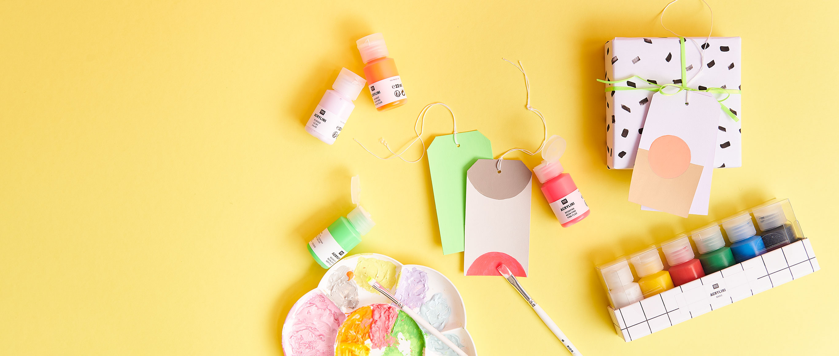 kleine Acrylfarbentuben und bemalte Geschenkanhänger