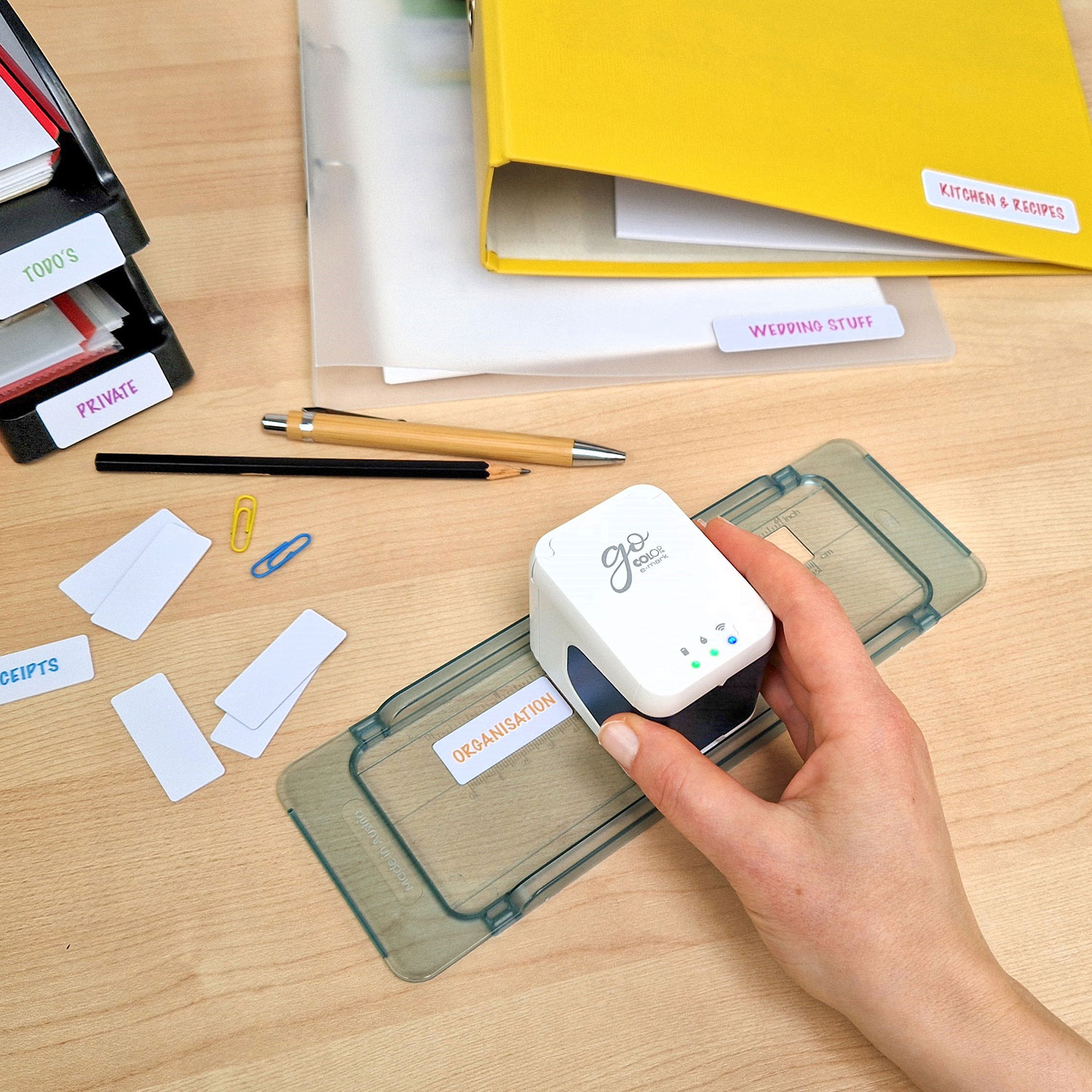 e-mark go Drucker wird von einer Frauenhand verwendet um Etiketten zu bedrucken