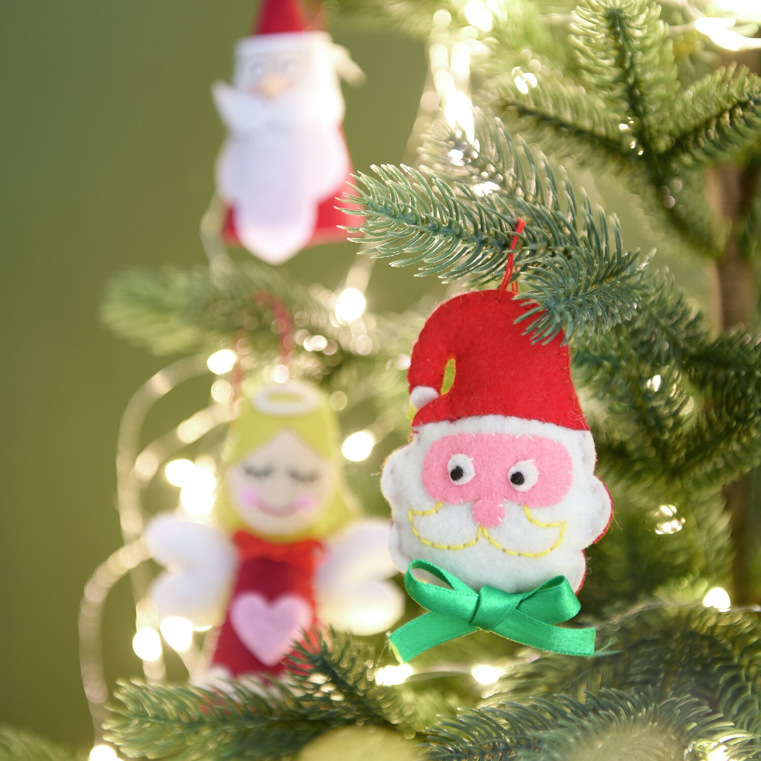 Aufhänger Filz-Santa mit Schleife Rot/Weiß: Weihnachtsschmuck am Baum, festlich dekoriert.