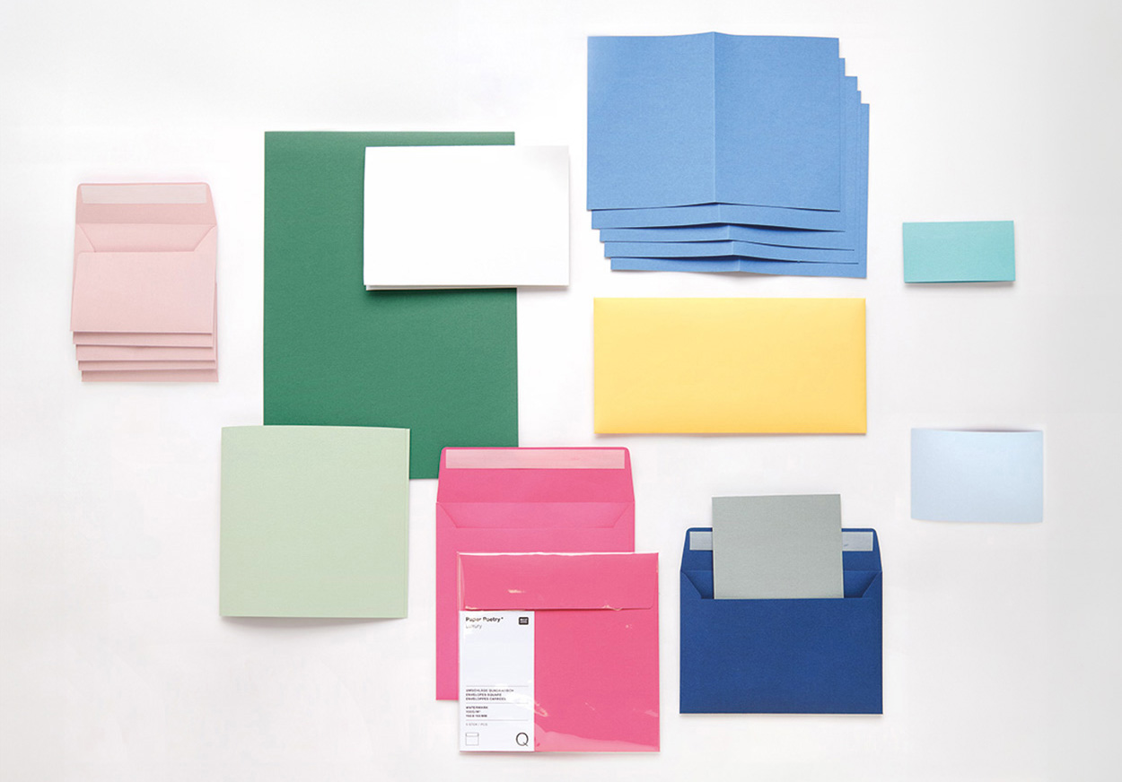 Umschläge und Karten in verschiedenen Farben und Größen teilweise übereinandergelegt. Flatlay von Produkten.