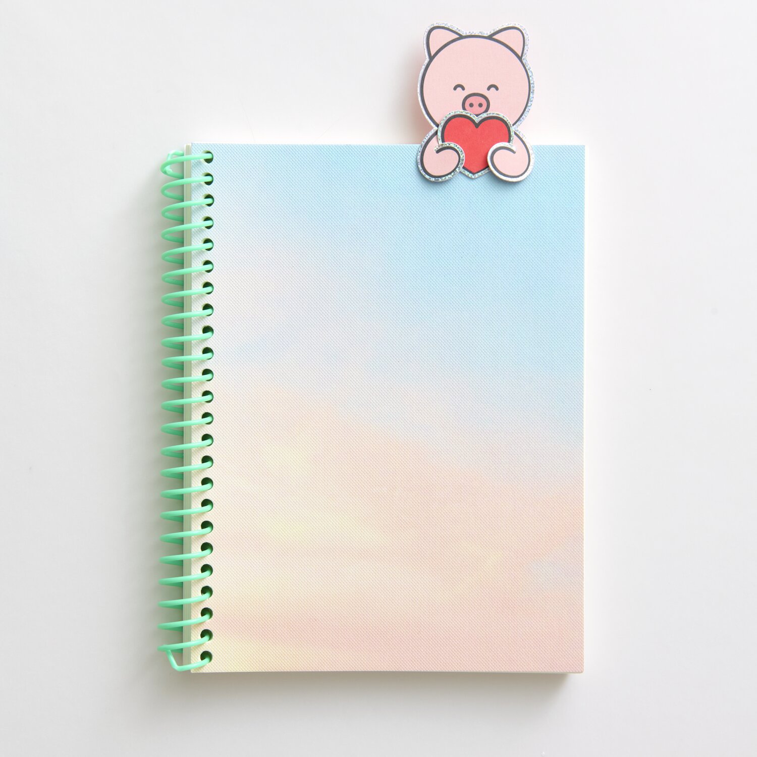 Paper Poetry Clip-Ons Chingu Tiere: Rosa Schweinchen-Clip auf pastellfarbenem Spiralblock.