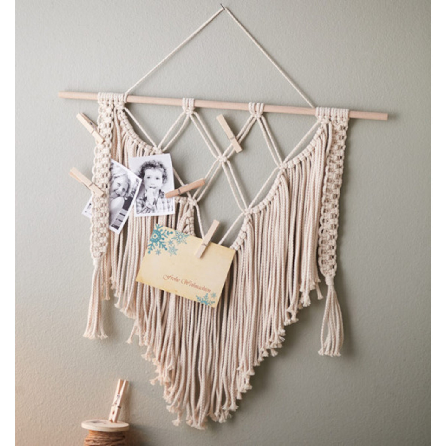 Makramee für Anfänger - Wandbehang aus beigem Garn mit Fotos und Briefen an Holzstab befestigt.