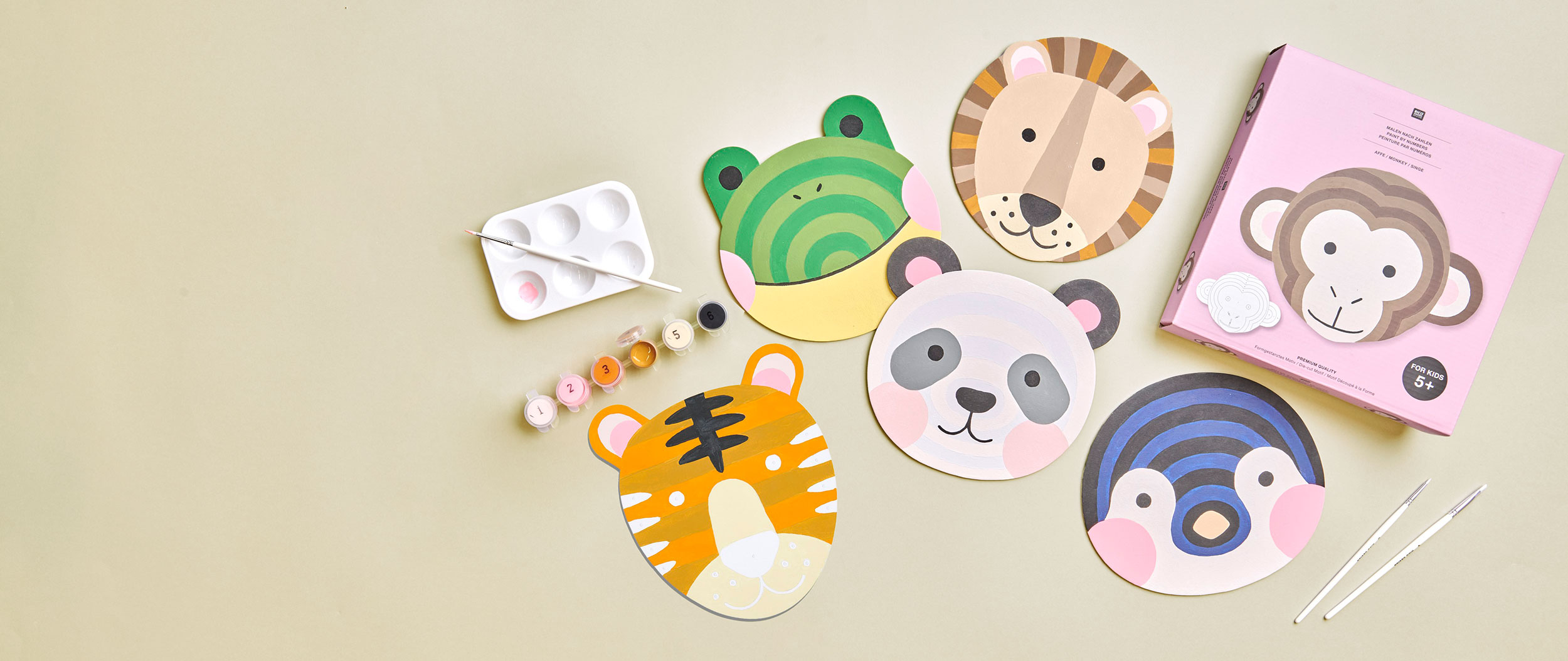 Verschiedene gemalte Tiergesichter mit Material und Verpackung. Flatlay von Produkten.