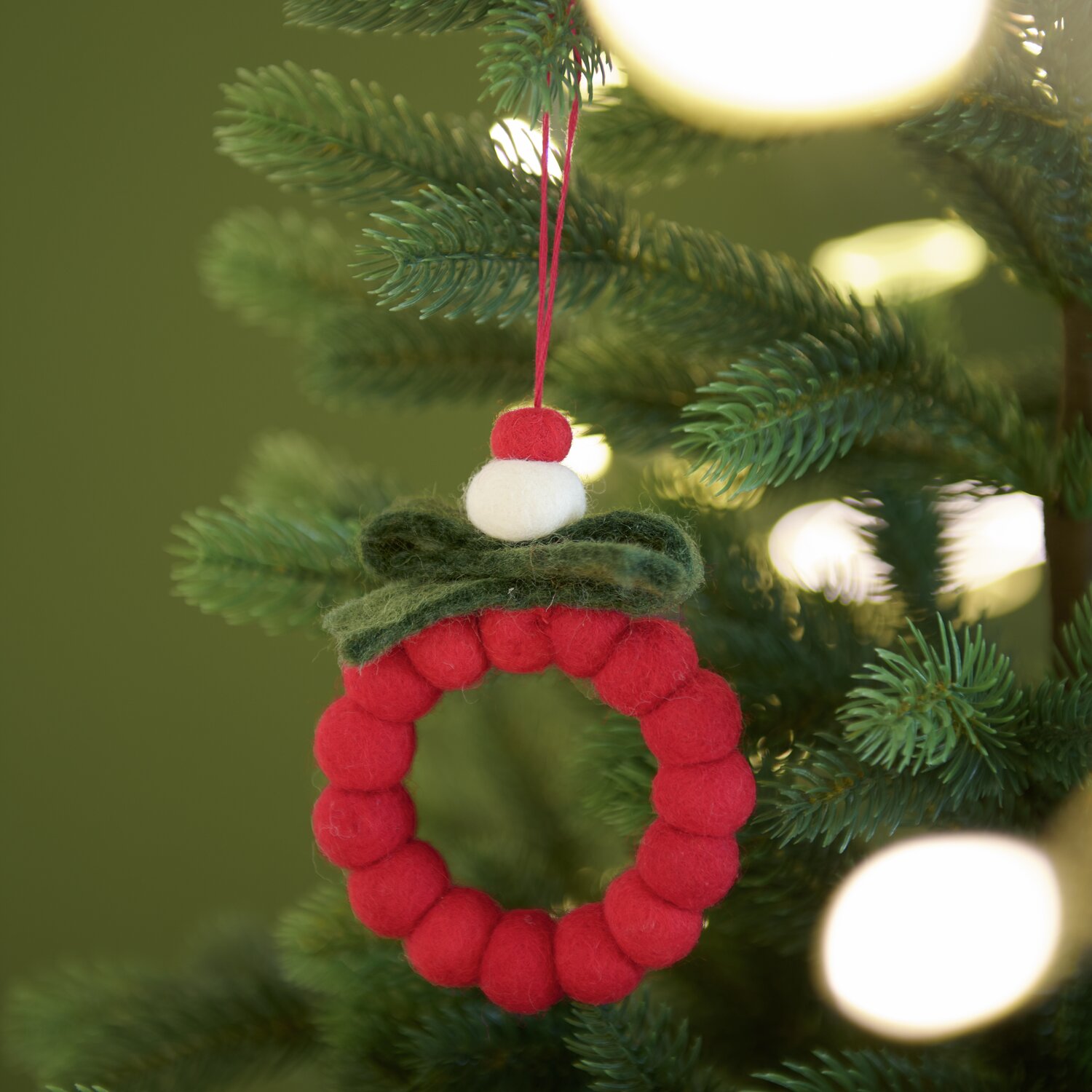 Aufhänger Filzkugeln Kranz Rot/Grün: Weihnachtlicher Schmuck aus roten Filzkugeln am Tannenbaum.