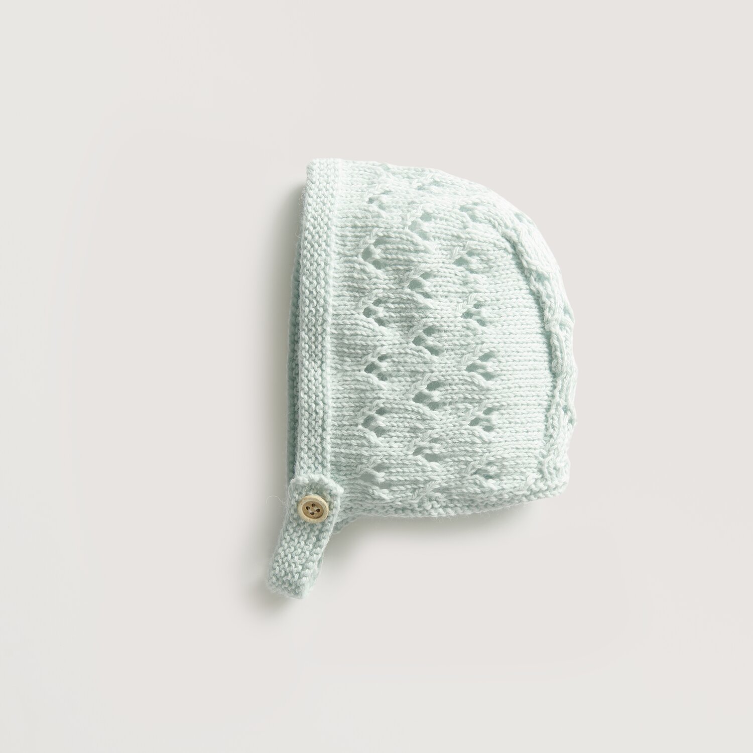 Baby Cozy Organic Cotton Cashmere: Hellblaue Babymütze aus Baumwolle und Kaschmir von Rico Design mit Knopfdetail.