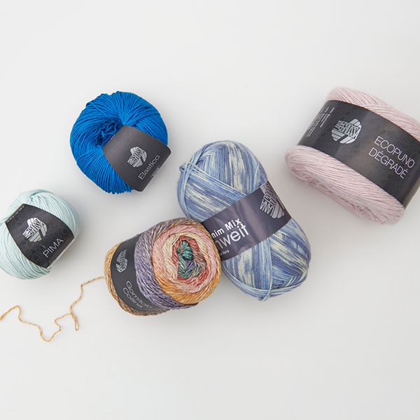 Vier unterschiedliche und bunte Lana Grossa Grane. Flatlay von Produkten.
