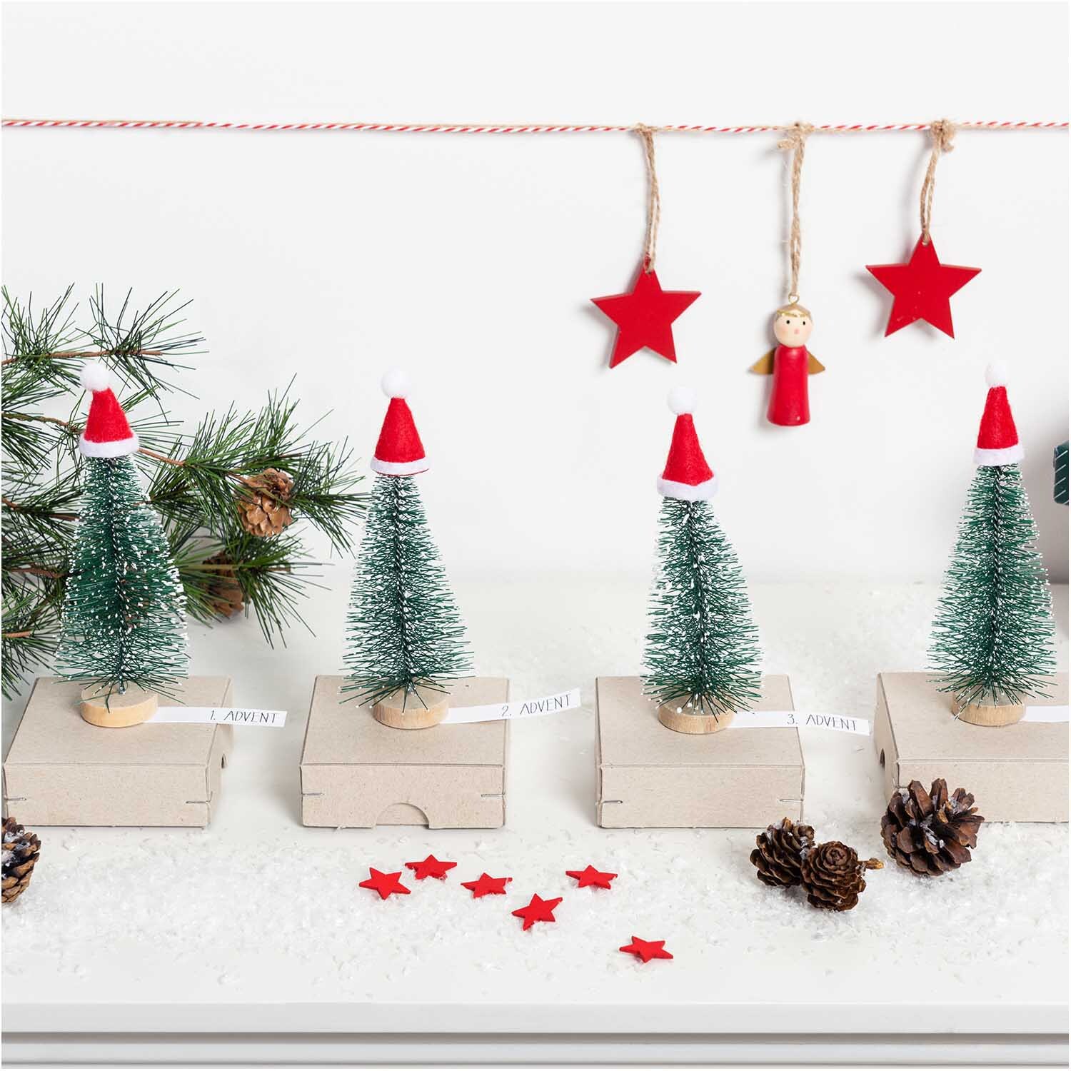 Holzhänger Stern von Rico Design: Weihnachtsdekoration mit roten Sternen und Tannenbäumen.