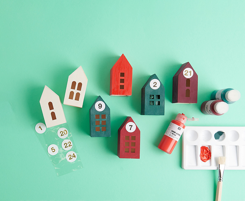 Papphäuser werden mit Acrylfarbe angemalt und mit Adventskalender Stickern beklebt
