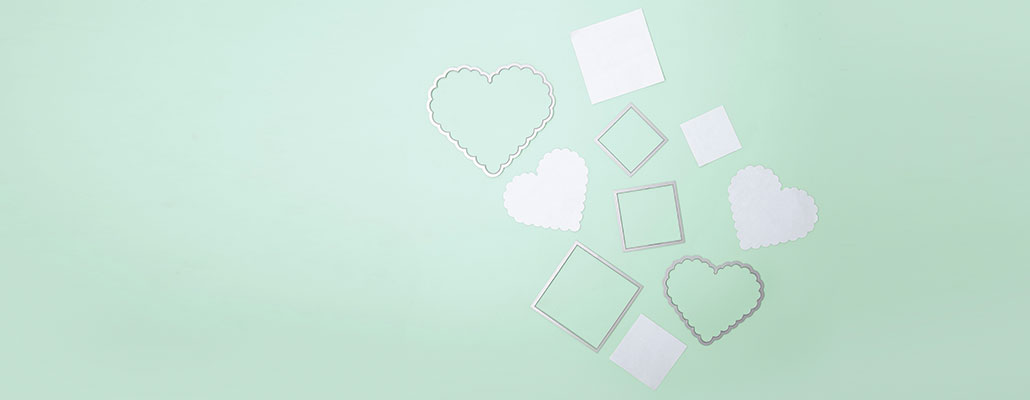 Framelits in Quadratformat und Herzform mit bereits ausgestanztem Papier in diesen Formen. Flatlay von Produkten.
